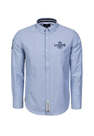 Hellblaues Hemd aus weichem Stoff mit langen Ärmeln, Kragen, besticktem Logo und einem Etikett an der unteren Seite.