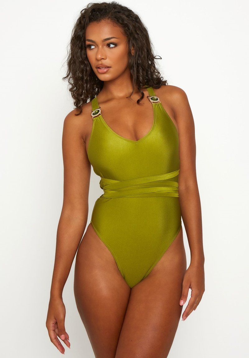 Maillot de bain une pièce vert olive avec bretelles réglables, décolleté en V et détail torsadé à la taille, avec accents métalliques. Texture lisse.