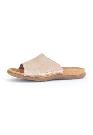 Beige suede slip-on sandal with an open toe, curved design, and stitched detailing along the edge. Cork footbed for comfort.