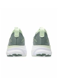Grüne und hellgrüne Sportschuhe mit einem Mesh-Obermaterial, gepolstertem weißen Zwischensohle, strukturierten Akzenten und Zuglaschen an der Ferse.