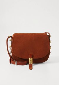 Hnědá semišová kabelka přes rameno s klopou, zlatými kovovými doplňky, nastavitelným popruhem a výrazným logem na kožené přezce.