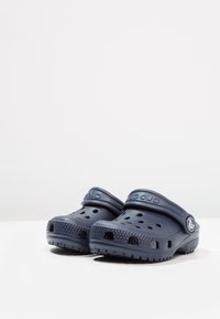 Crocs blu navy con design perforato, suole spesse e cinturino sul tallone per una vestibilità sicura. Realizzati in materiale leggero e resistente.