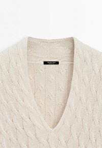 Pull en maille torsadée crème à col en V avec motif texturé et étiquette Massimo Dutti cousue à l'intérieur du col.