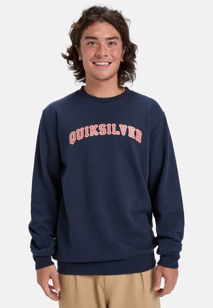 Navy blue sweatshirt made of cotton blend, featuring a crew neck and long sleeves. "QUIKSILVER" in curved, light orange text across the chest.