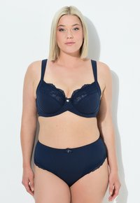 Navy sininen rintaliivi ja korkeavyötäröiset alushousut textured-kankaasta, joissa on pitsireunus ja koristeellinen sulka keskellä etuosaa.