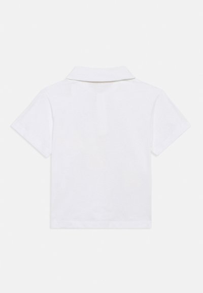 Λευκό πόλο μπλουζάκι με κοντά μανίκια, κλασικό γιακά και λεία υφή βαμβακιού. Απλό και μονόχρωμο χωρίς σχέδια ή διακοσμητικά στοιχεία.