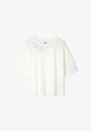 Biała koszulka z krótkim rękawem o luźnym kroju. Posiada kwiatowe hafty w jasnoniebieskim i srebrnym kolorze na przodzie i rękawach.