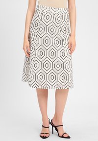A knee-length skirt featuring a geometric hexagon pattern in black and white, made from a textured fabric with a fitted waist.