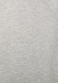 Tejido de algodón gris con una textura suave, que muestra una superficie lisa y uniforme sin patrones ni acentos, adecuado para ropa casual.