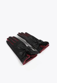 Czarne skórzane rękawiczki z czerwonymi akcentami, z ozdobą w postaci kokardy przy nadgarstku. Gładka faktura, klasyczny design i trzy segmenty na palce.