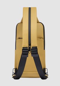 Zaino giallo con esterno liscio, due spallacci neri regolabili, una cerniera centrale e una tasca laterale per accessori.