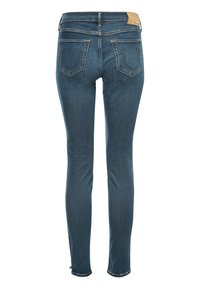 Jean skinny en denim bleu vu de dos avec deux poches et une étiquette de marque en cuir tan sur la ceinture.