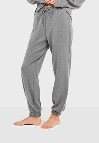 Pantalones jogger de algodón gris con cinturilla ajustable, puños entallados y bolsillos laterales, que presentan una textura suave y un ajuste relajado.