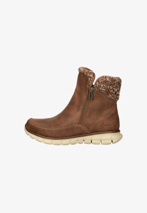 Braune Knöchelstiefel aus weichem Wildleder mit einem strukturierten Strickkragen und seitlichem Reißverschluss, ausgestattet mit einer flexiblen weißen Sohle für zusätzlichen Komfort.