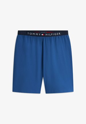 Blaue Herren-Boxershorts mit schwarzem Bund, der weißen "Tommy Hilfiger"-Schriftzug und ein rotes, weißes und blaues Logo in der Mitte zeigt.