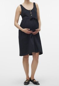 Svart gravidklänning med rundad halsringning, knapprader fram, midjeband och en avslappnad passform som faller över magen.