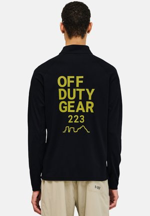 Zwarte longsleeve shirt van een gestructureerde stof met grote gele bedrukking: "OFF DUTY GEAR 223" en een geometrisch skyline-omtrek op de achterkant.