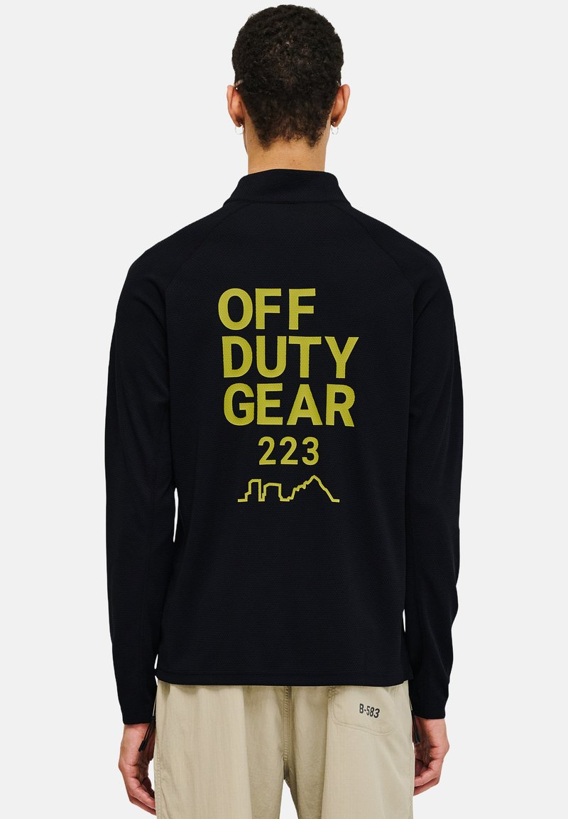 Schwarzes Langarmhemd aus strukturiertem Stoff mit großem gelbem Drucktext: "OFF DUTY GEAR 223" und einer geometrischen Skyline-Kontur auf der Rückseite.
