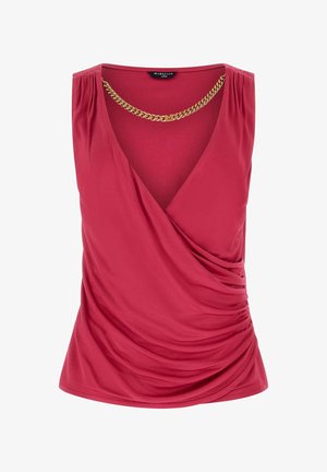 Różowy top bez rękawów w stylu kopertowym z marszczeniem po bokach oraz ozdobnym złotym łańcuszkiem przy głębokim dekolcie w kształcie litery V.