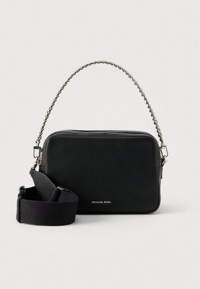 Sac d'épaule rectangulaire Michael Kors noir texturé avec poignée en chaîne argentée et bandoulière large noire amovible sur fond blanc.