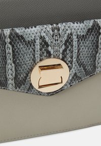 Borsa grigia strutturata con una patta a stampa serpente testurizzata in bianco e nero, accentuata da una chiusura in metallo dorato.