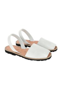 Sandales slingback en cuir blanc avec une semelle plate en caoutchouc noir et des coutures minimales, présentant un bout carré et un design ouvert à l'arrière.