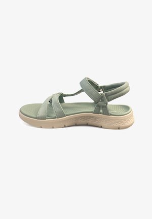 Sandalo in tessuto verde con cinghie incrociate, suola in gomma, soletta testurizzata, cinturini alla caviglia imbottiti e una suola intermedia di color beige chiaro.