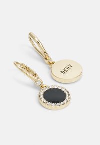 Cercei cu nuanță de aur, având un charm rotund negru înconjurat de cristale clare, cu un logo DKNY pe un disc lustruit.