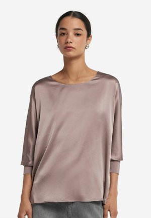 Satinblus i mjuk mauve, med bred rund halsringning och trekvartsärmar. Slät textur med en avslappnad passform och inga synliga knäppningar.