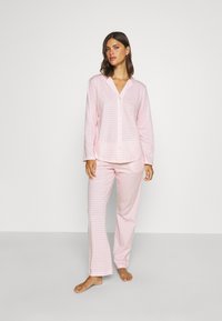 En rosa och vit rutigt pyjamas-set som består av en knapp-up skjorta med krage och långa ärmar, tillsammans med matchande rak ben-byxor.