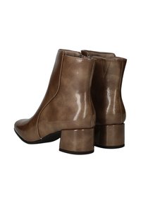 Bottines taupe avec une finition brillante, bout rond et talon bloc épais. Équipées d'une fermeture éclair sur le côté et de légères variations de texture.