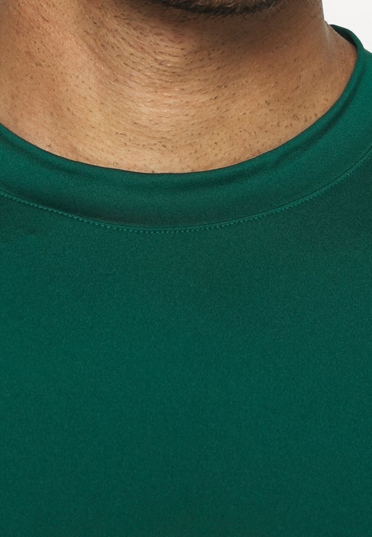 Camisa verde de manga corta con una textura suave, con un cuello redondo y costuras reforzadas en los bordes.