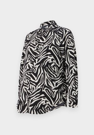 Long-sleeved black and white button-up shirt featuring a bold zebra stripe pattern, smooth fabric, and a classic collar design.
