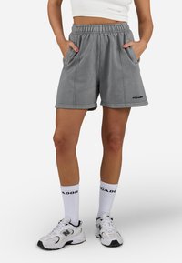Gray cotton shorts with an elastic waistband, two side pockets, and subtle stitching details. Black branding visible on the leg.