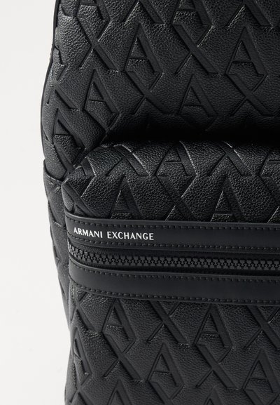 Sac à dos noir texturé avec un design de logo en relief, une poignée supérieure et un compartiment zippé avec l'étiquette de la marque "ARMANI EXCHANGE".