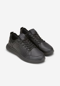 Scarpe sportive nere in materiale sintetico, con collo imbottito, dettagli testurizzati e suola flessibile con chiusura a lacci.