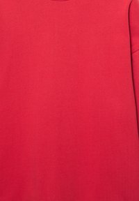 Rode trui met een gladde textuur, ronde halslijn en lange mouwen. De stof is zacht en licht rekbaar, met een effen kleur zonder patronen.