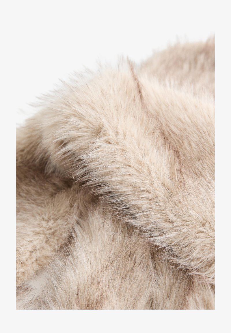 Faux-Fur-Stoff in hellem Beige mit einer weichen, flauschigen Textur. Weist leichte Farb- und Längenvariationen auf, die Tiefe und Interesse schaffen.