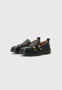 Mocassini in pelle nera con dettagli in oro, tacco basso e design a punta tonda; texture liscia con stile slip-on e linguetta sul retro.