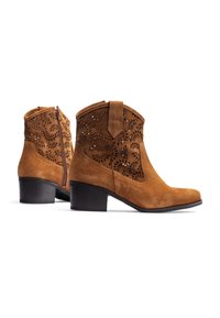 Brown suede ankle boots with laser-cut floral designs, a side zipper, and a black block heel. Features a rounded toe and stitching accents.