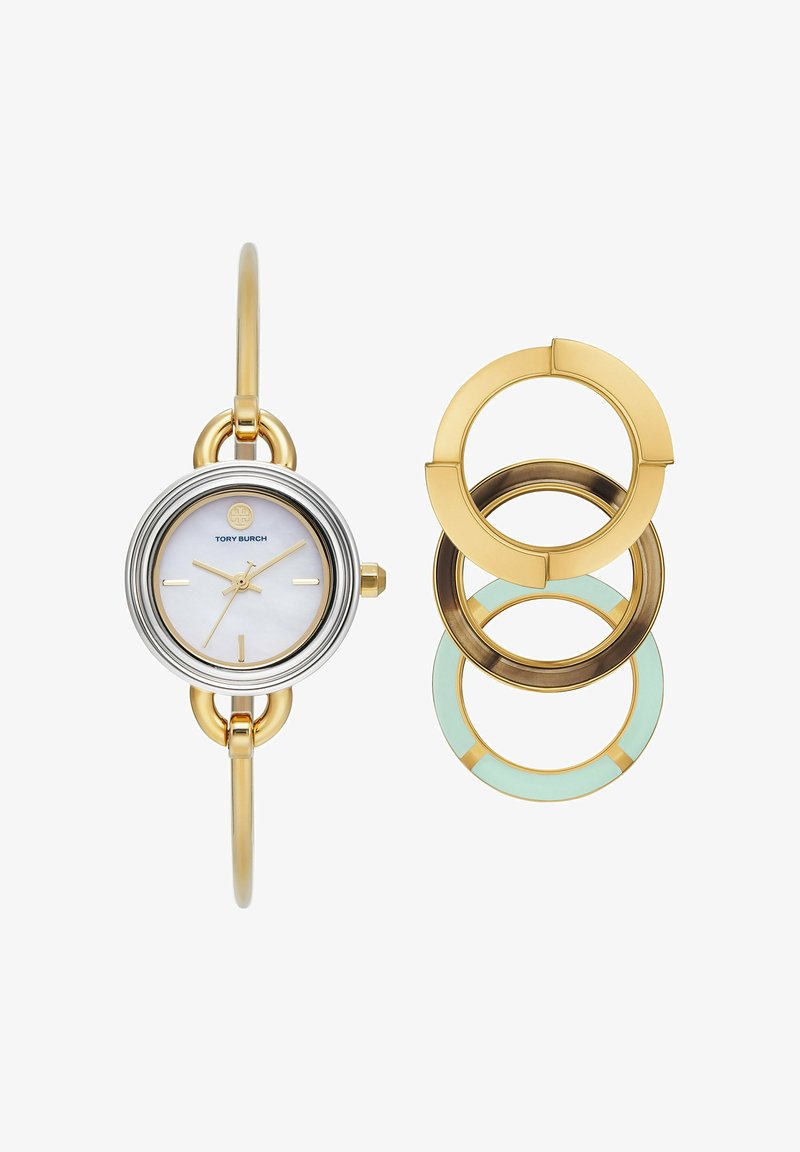 Montre-bracelet en or et argent avec cadran blanc et marqueurs dorés, présentée avec trois anneaux décoratifs interchangeables en or, bronze et vert menthe.