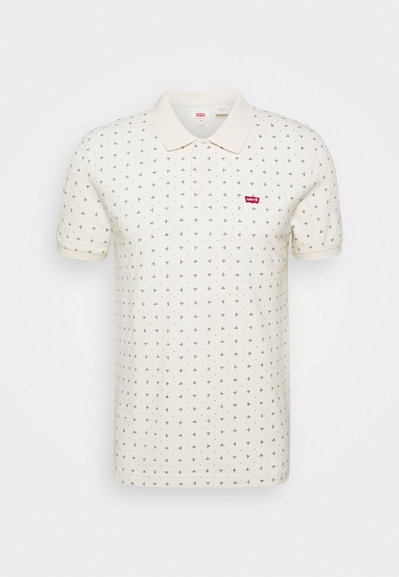 Polo crème à manches courtes avec un petit motif de feuilles noires et le logo rouge Levi's sur la poitrine gauche.
