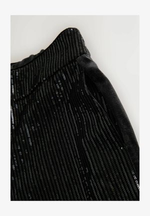 Tela negra con rayas de lentejuelas verticales, que presenta una textura suave y una cintura de terciopelo blandita. El detalle enfatiza el brillo y el patrón.