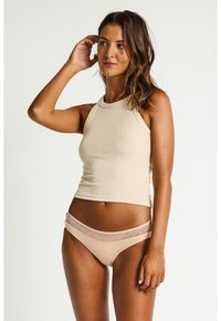 Débardeur côtelé beige associé à un bikini taille basse assorti, doté d'une ceinture élastique à motif. Texture lisse et design ajusté.