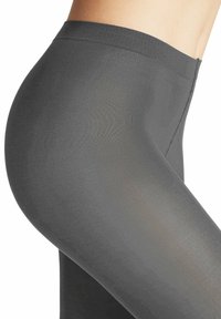 Primo piano di leggings grigi scuri, che mostrano un tessuto testurizzato e linee morbide lungo la vita e l'area della coscia.