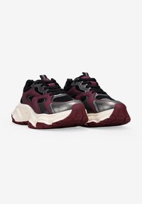 Zapatillas negras y maroon con suela gruesa, acentos metálicos, paneles de malla y cordones negros. Suela de goma texturizada.