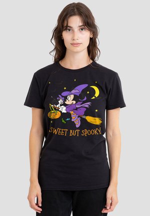 Black cotton t-shirt featuring a graphic of a witch and cat on a broomstick, surrounded by stars. Text reads "SWEET BUT SPOOKY" in orange.