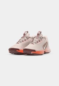 Nike Trailrunning-Schuhe mit einem hellrosa Netz-Obermaterial, einer strukturierten orangenen Sohle und gemusterten Schnürsenkeln mit einem kontrastierenden Logodetail.