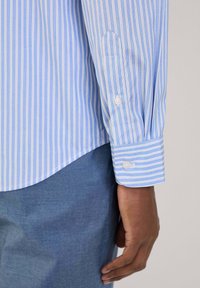 Lichtblauw gestreept overhemd met witte verticale strepen, knoopmanchetten en een licht gebogen zoom. Geweven stof, getailleerd ontwerp, casual kleding.