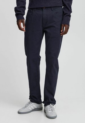 Chino navy realizzati in tessuto liscio, caratterizzati da una vestibilità dritta, design a cinque tasche e sottili dettagli di cucitura. Abbinati a sneaker grigio chiaro.